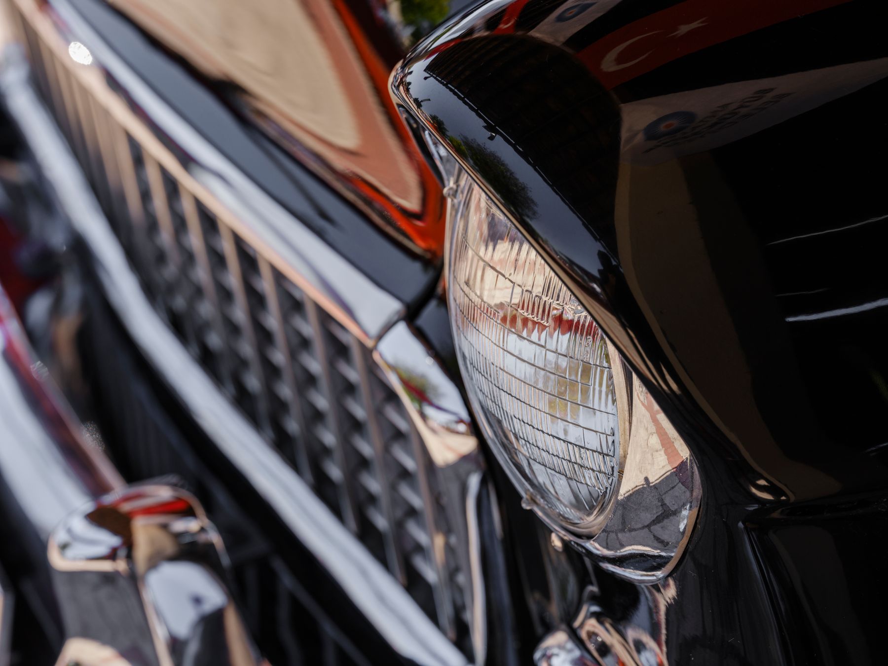 Polished chrome and headlight surfaces reflecting nearby light